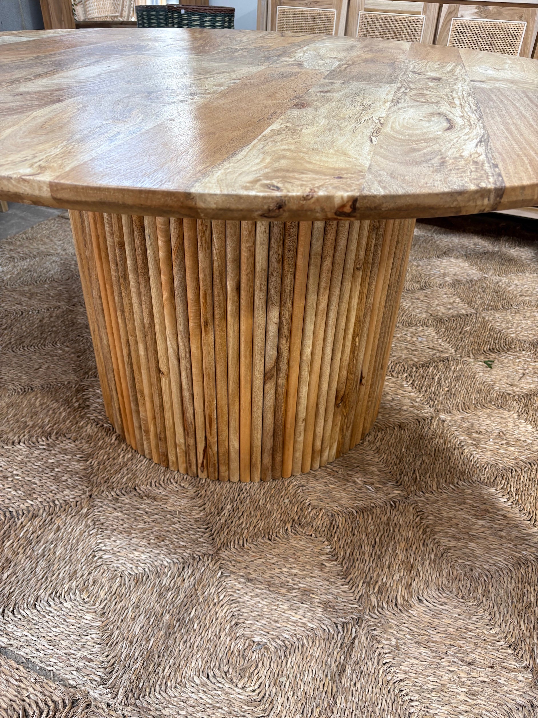The Charles 1350 Dining Table is a contemporary round dining table. Featuring a sustainable Fruitwood top and slated column fruitwood base. Colour natural. Measures 1350 diameter X 760 height. Angle.