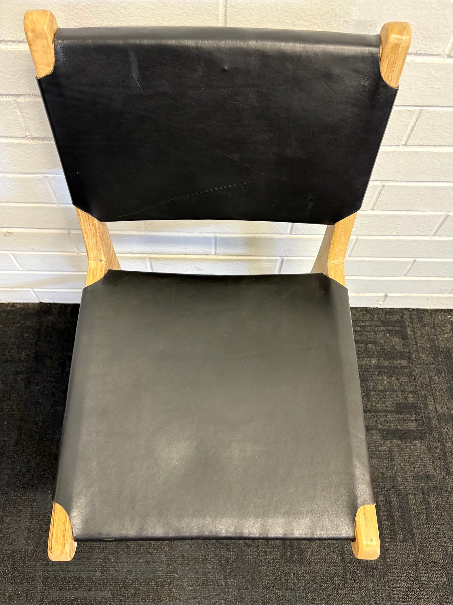 The Cherokee - Black Dining Chair is crafted from solid teak with a smooth black leather seat and back. Colours natural frame with black seat and back. Measures 560 Depth x 450 Wide x 500 Seat Height. Back height 820. Top.