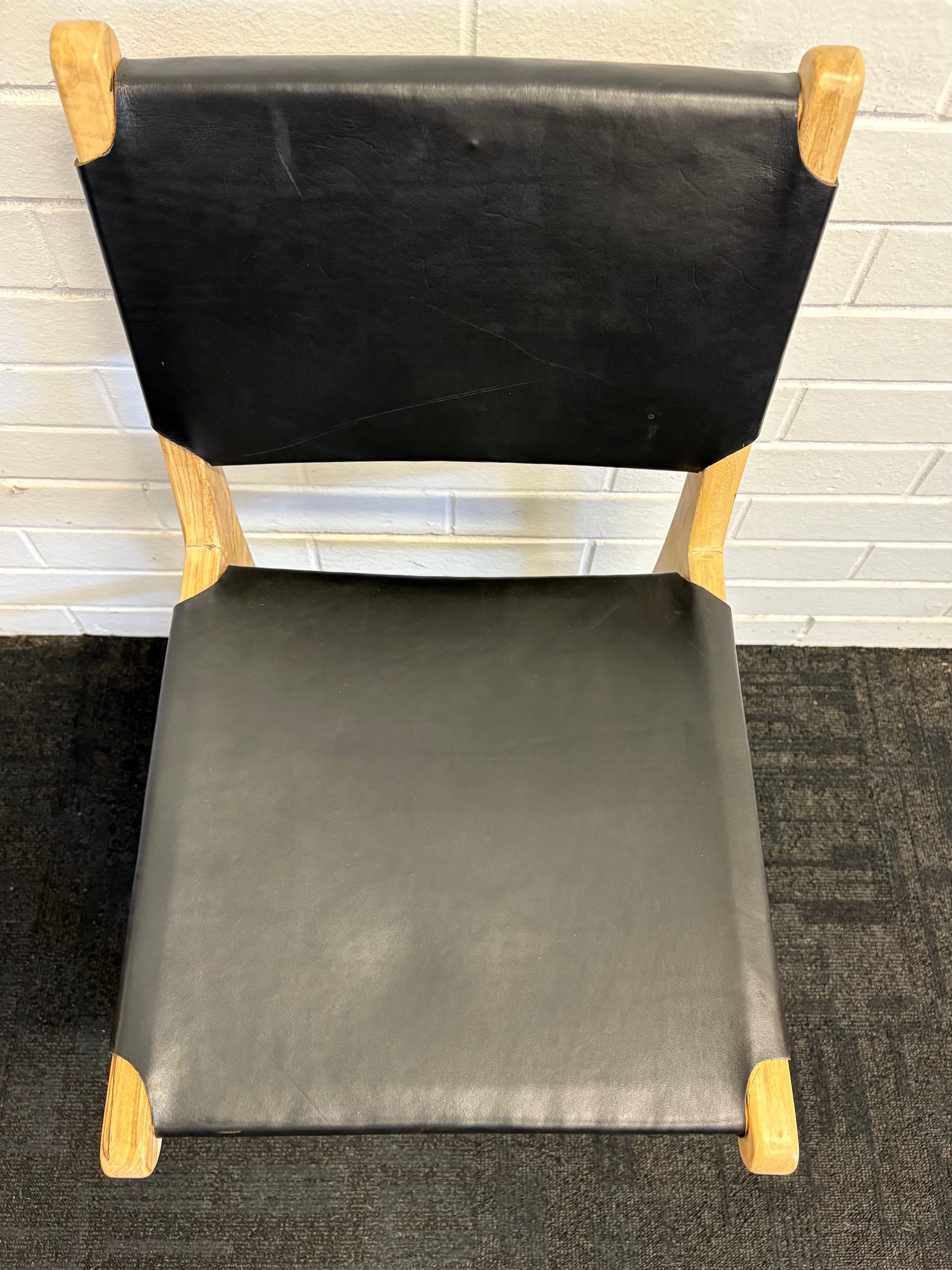 The Cherokee - Black Dining Chair is crafted from solid teak with a smooth black leather seat and back. Colours natural frame with black seat and back. Measures 560 Depth x 450 Wide x 500 Seat Height. Back height 820. Top.