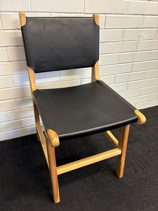 The Cherokee - Black Dining Chair is crafted from solid teak with a smooth black leather seat and back. Colours natural frame with black seat and back. Measures 560 Depth x 450 Wide x 500 Seat Height. Back height 820. Top Angle.