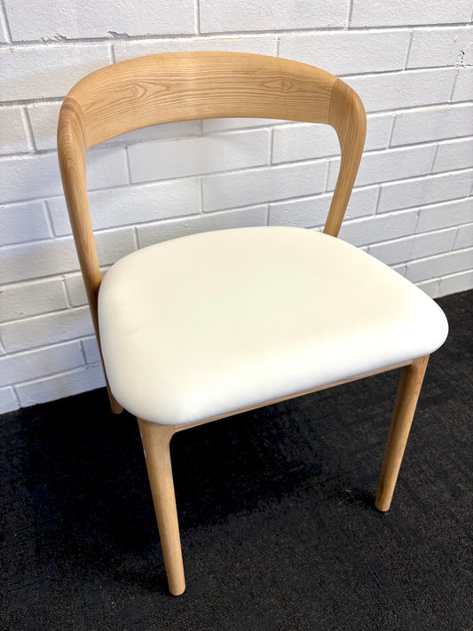 The Cheyenne Natural and White dining chair features a modern style and design. Crafted with a solid ash frame and a smooth padded white polyurethane seat. Colour Natural Frame with White seat. Measures 500 wide X 520 depth X 460 Seat height. Back height 750. Angle.
