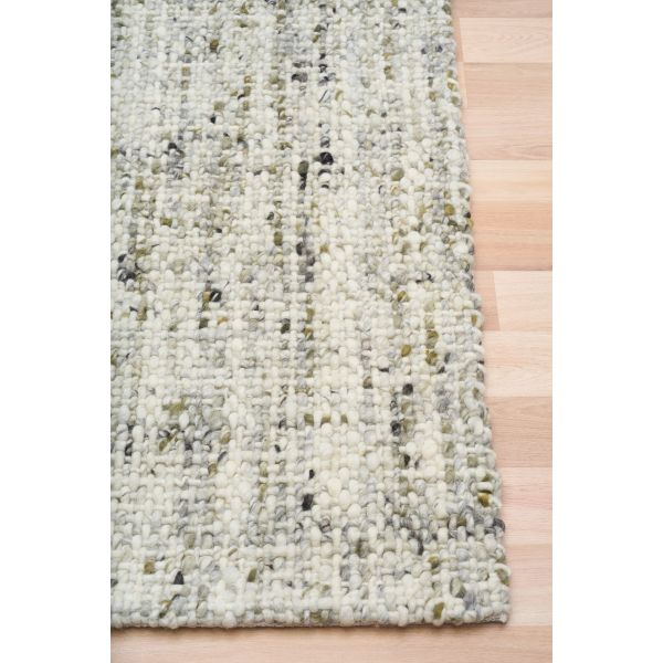 Cleo Green hand-woven wool flatweave rug in a muted olive tone, with a flecked, cross-woven texture and flat woven border. 3 Sizes. Corner view.