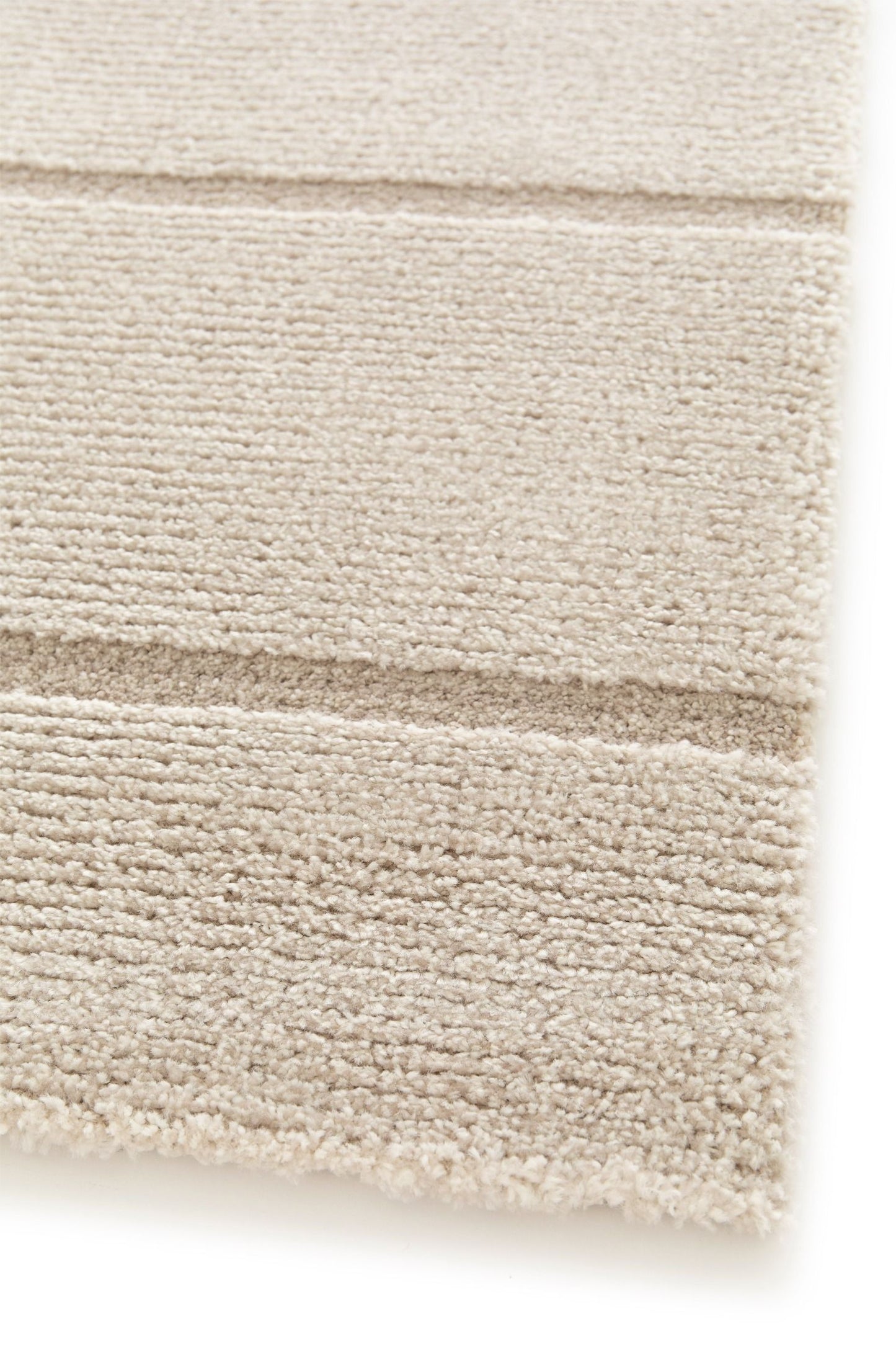 Cocoon - Beige, a modern rug design crafted with a unique blend of Heat Set Polypropylene and Polyester shrink yarn. Corner.