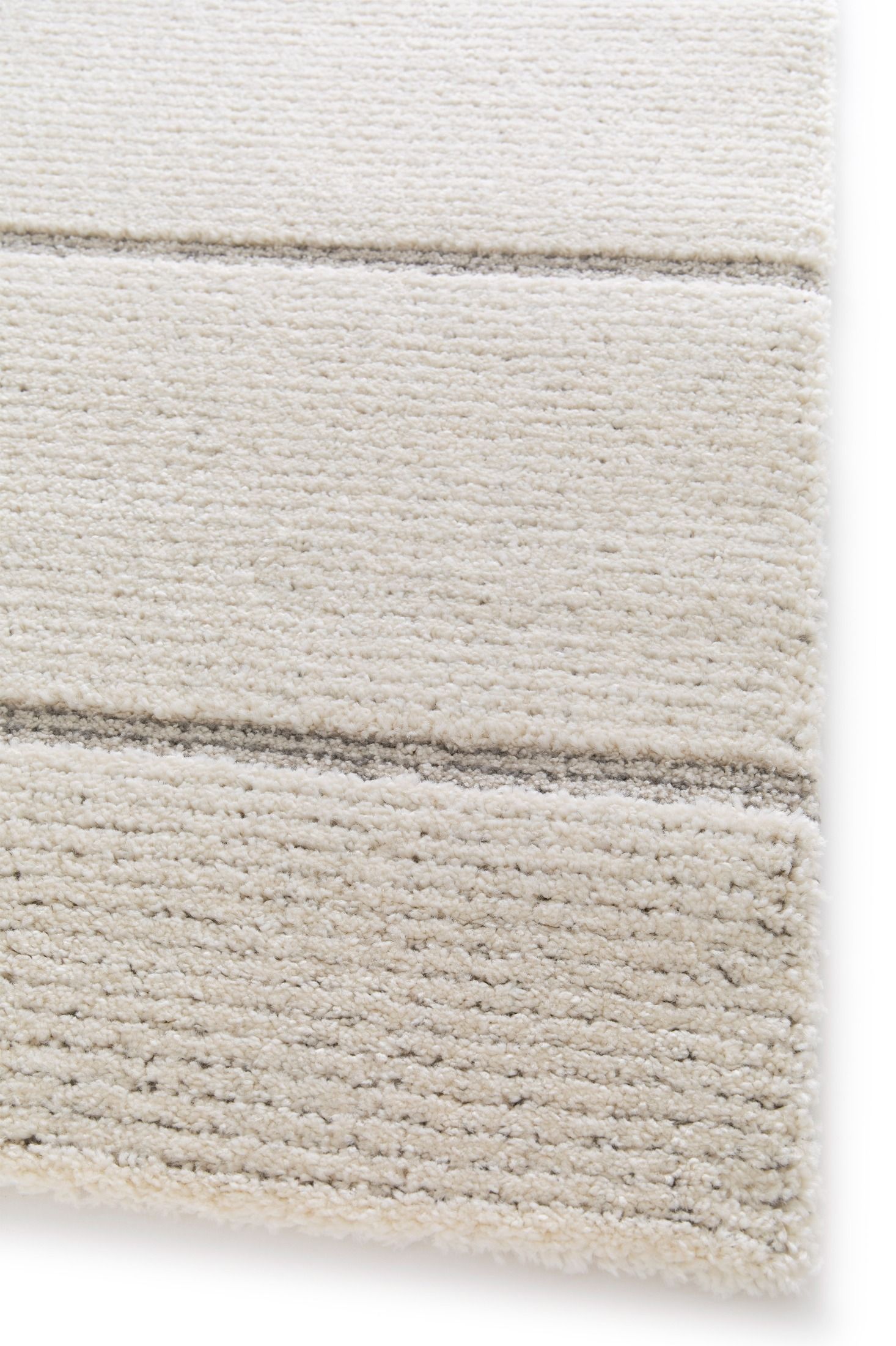 Cocoon - Light Grey, a modern rug design crafted with a unique blend of Heat Set Polypropylene and Polyester shrink yarn. Corner.