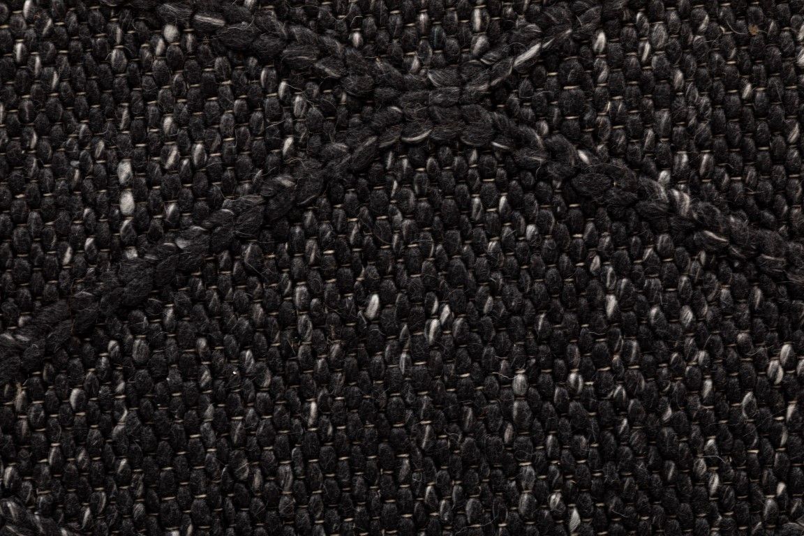 The Colombo Runner - Graphite is a textured hand woven hallway runner rug. Made from 80% wool and 20% polyester, it features a braided diamond pattern for an extra textured feel.  Colour Graphite. Size 80 wide x 320 Length. Close.