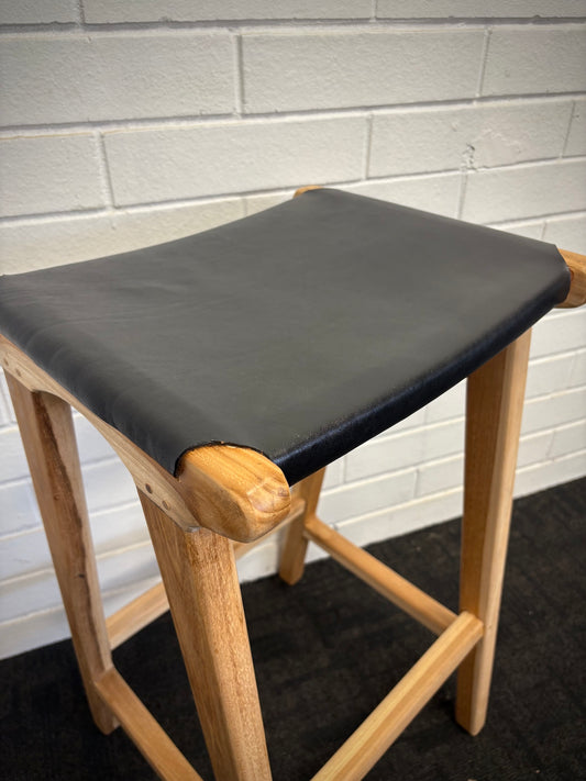 The Columbia - Black Leather barstool features a lush leather seat and sustainable teak framed legs. Colour natural teak frame with black leather seat. Measures 400 wide X 400 depth X 650 Seat height. Angle.