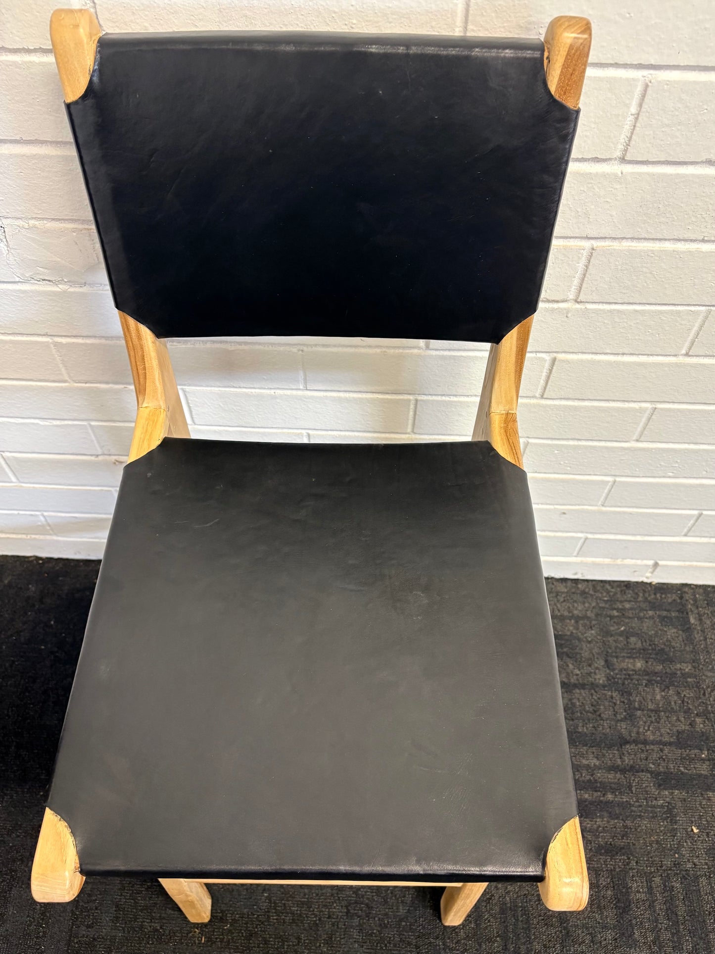 The Columbia with Back - Black Leather barstool features a black leather seat and back with sustainable teak framed legs. Colour natural teak frame with black leather seat and back. Measures 400 wide X 400 depth X 680 Seat height X 1000 Back height. Top.