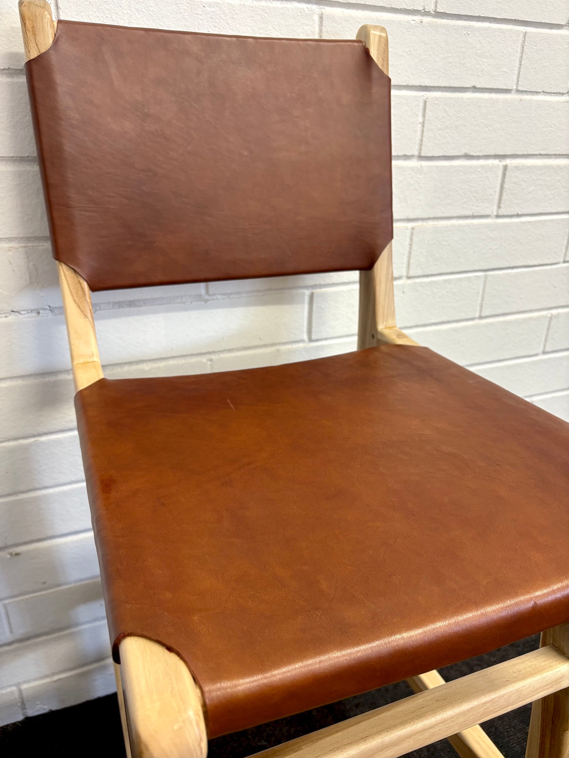The Columbia with Back - Brown Leather barstool features a black leather seat and back with sustainable teak framed legs. Colour natural teak frame with brown leather seat and back. Measures 400 wide X 400 depth X 680 Seat height X 1000 Back height.  Close.