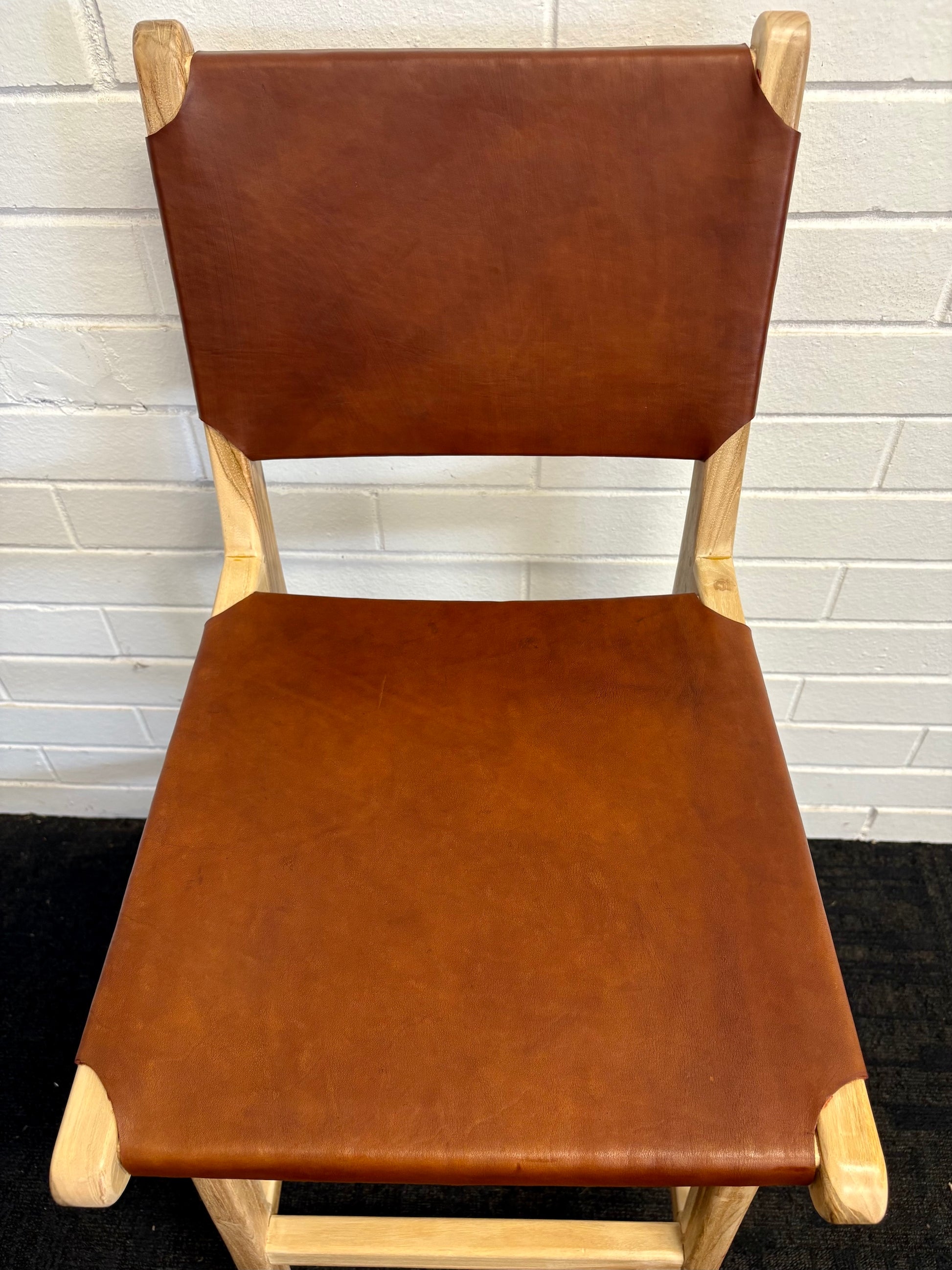 The Columbia with Back - Brown Leather barstool features a black leather seat and back with sustainable teak framed legs. Colour natural teak frame with brown leather seat and back. Measures 400 wide X 400 depth X 680 Seat height X 1000 Back height. Top.