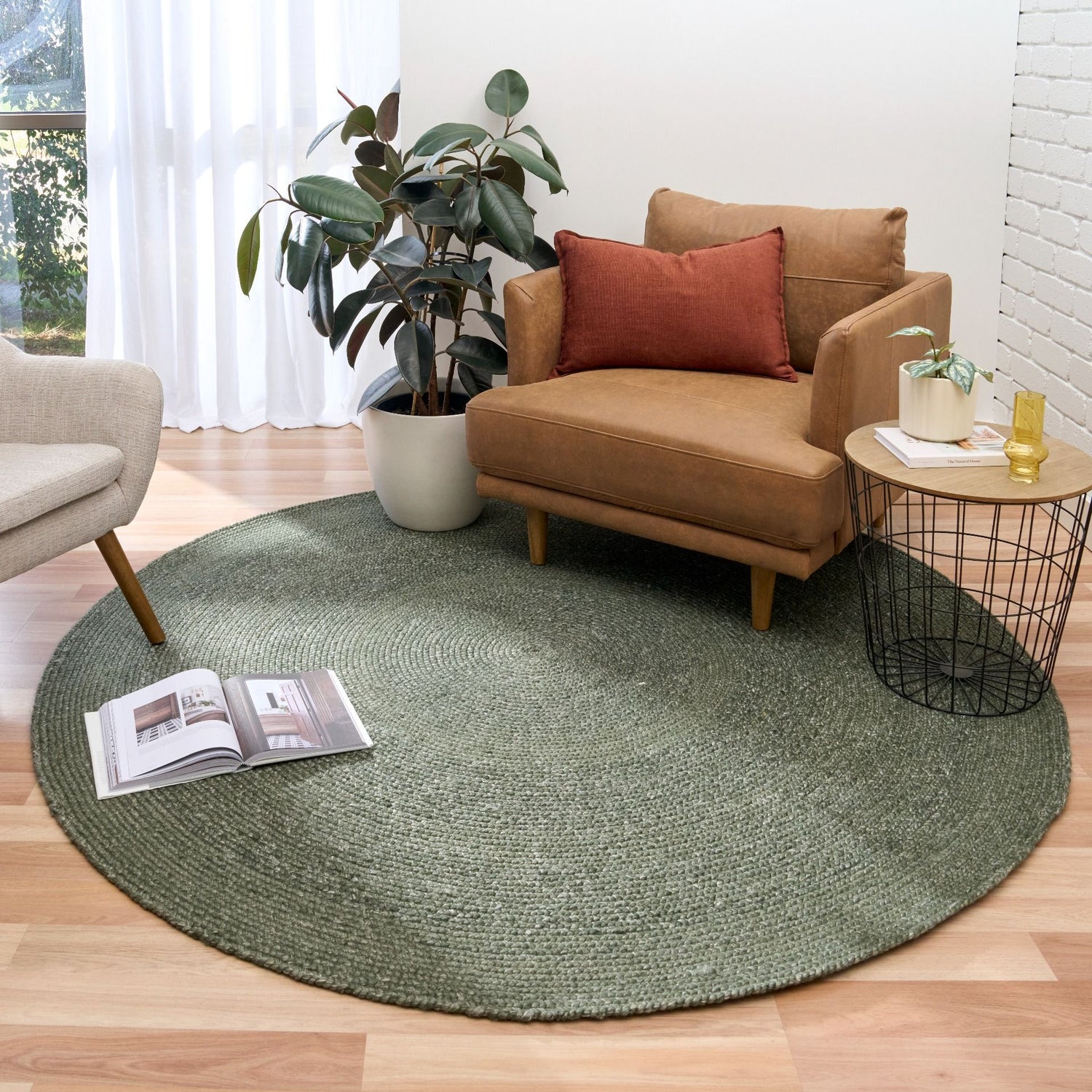 Cora Round Olive Rug hand woven from 70% New Zealand wool and 30% viscose in a braided weave. Colour Dark Olive. 2 sizes, 200cm round and 250cm round. Styled View.