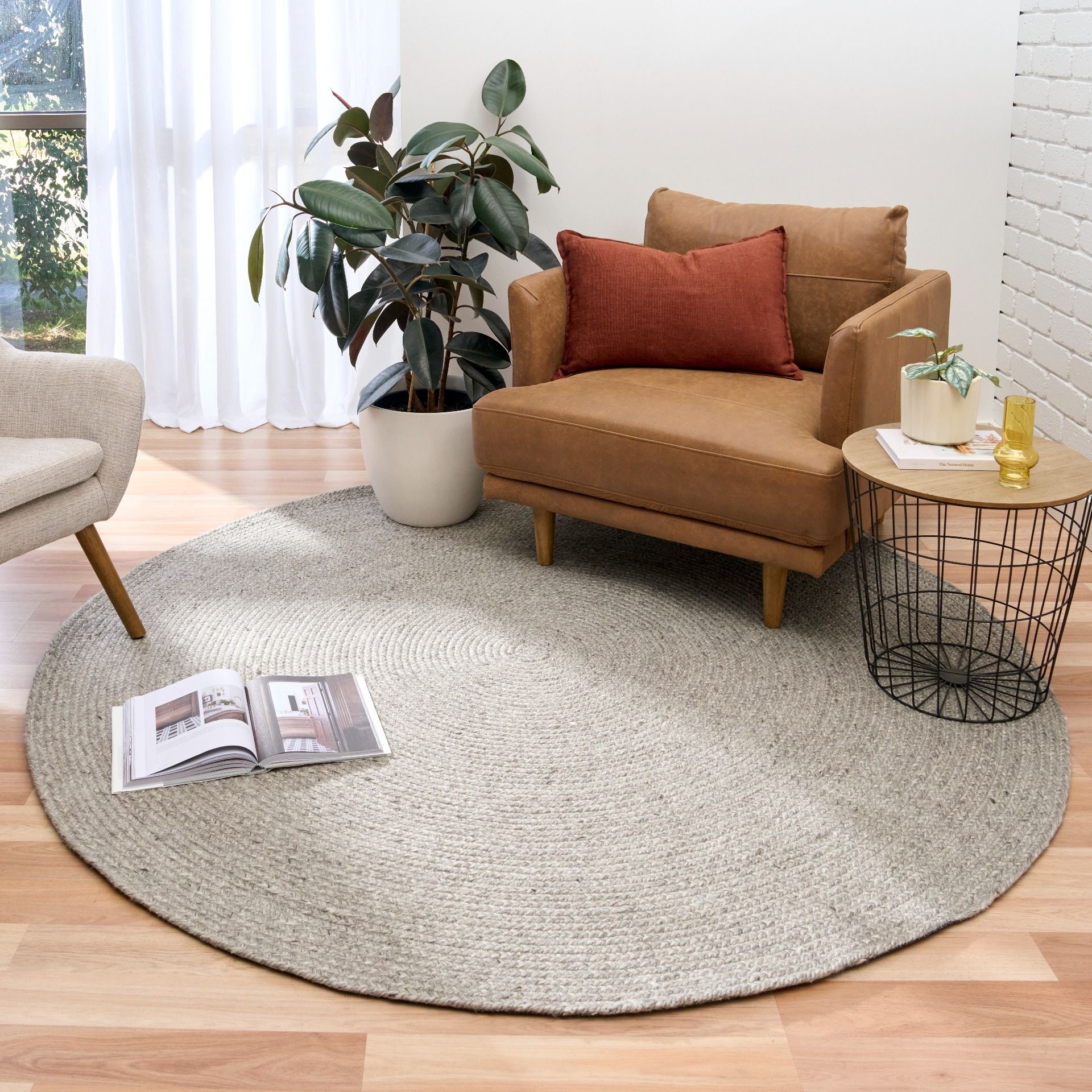 Cora Round Silver Rug hand woven from 70% New Zealand wool and 30% viscose in a braided weave. Colour Silver Grey. 2 sizes, 200cm round and 250cm round. Styled View.