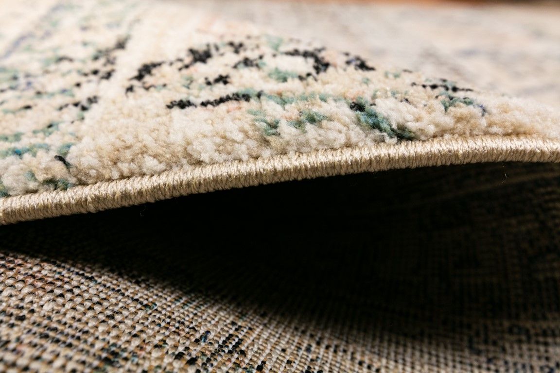 Cozy 5434 Ivory Beige is a tribal patterned designed machine made rug. Constructed from luxurious polyester yarn, it features a soft feel.  Colours  Ivory Beige with Cream, Black and Blue Tribal Patterns. Size 160 X 230 and 200 X 290. Side.