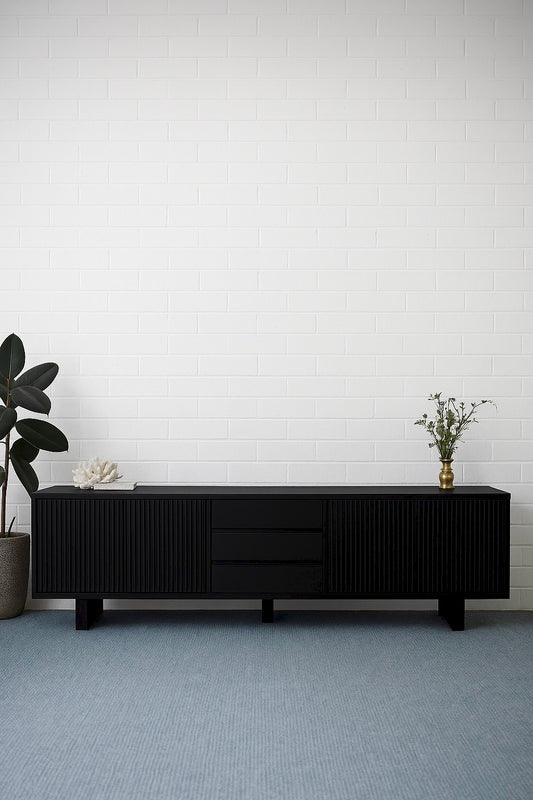 The Crosby Black Entertainment Unit, featuring 4 Sliding Doors and 3 drawers. This entertainment unit boasts a modern design and ample storage. Crafted from solid white cedar. Colour Black. Measures 2500 Length x 400 Depth x 600 Height. Styled.