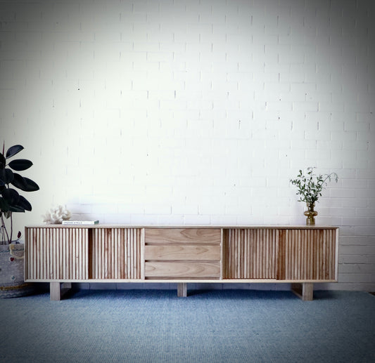 The Crosby Natural, featuring 4 Sliding Doors and 3 drawers. This entertainment unit boasts a modern design and ample storage. Crafted from solid white cedar. Colour Natural. Measures 2500 Length x 400 Depth x 600 Height. Front Styled.