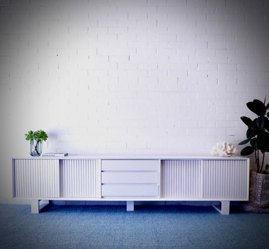 The Crosby Black Entertainment Unit, featuring 4 Sliding Doors and 3 drawers. This entertainment unit boasts a modern design and ample storage. Crafted from solid white cedar. Colour Black. Measures 2500 Length x 400 Depth x 600 Height. Styled.