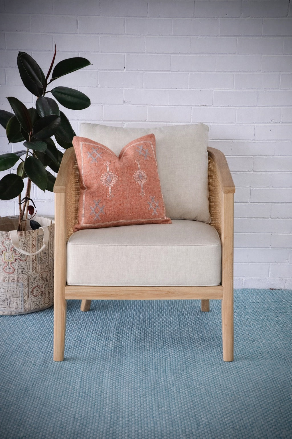 The Daisy Occasional Chair. Teak Frame wrapped in open mesh rattan. Includes cushioned seat and back. Colour Natural Teak and Rattan with cream cotton twill cushions. Measures 700 Wide X 800 Depth X 750 Back Height. Styled.