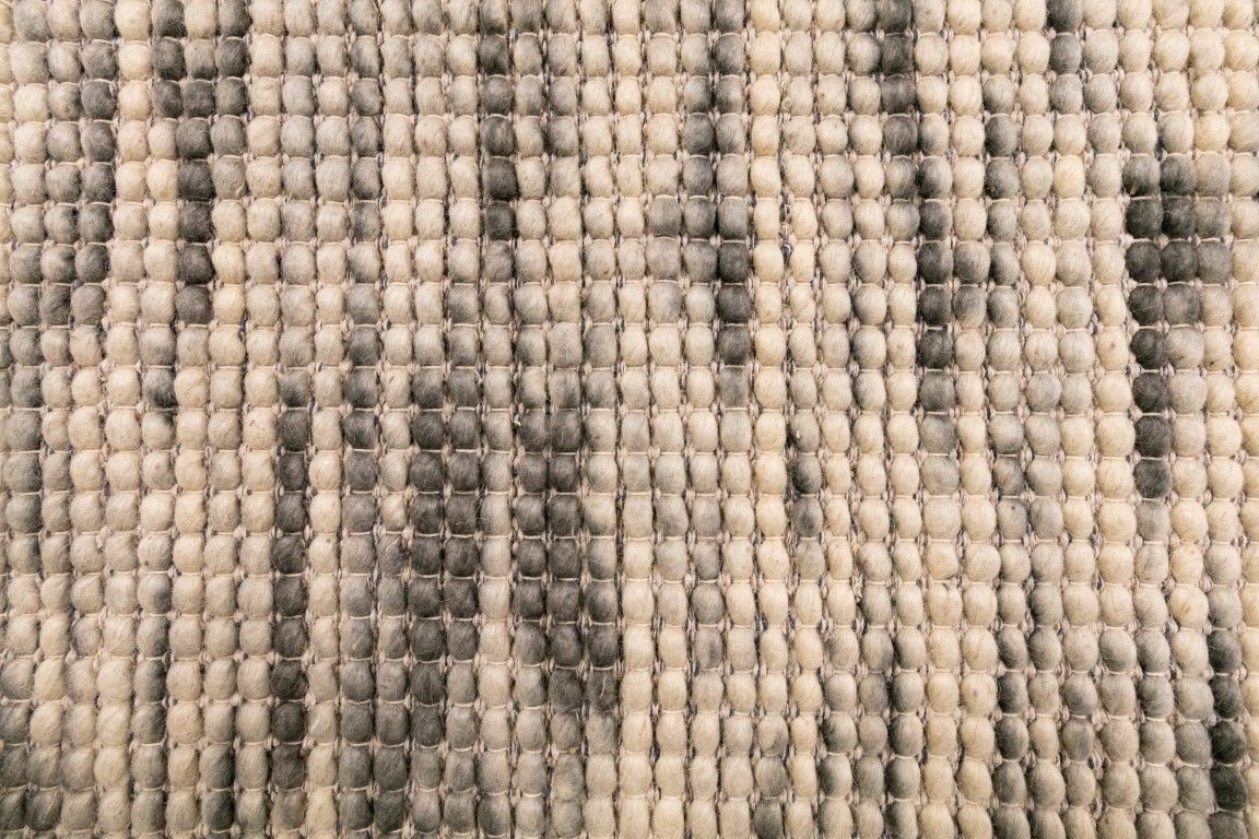 Dasha Zephyr is a texture hand woven rug made of 80%  New Zealand Wool and 20% Polyester. Colour Light Beige with Emerald Green accents. Sizes 155 X 225, 200 X 290, 240 X 320 and 300 X 400. Close.
