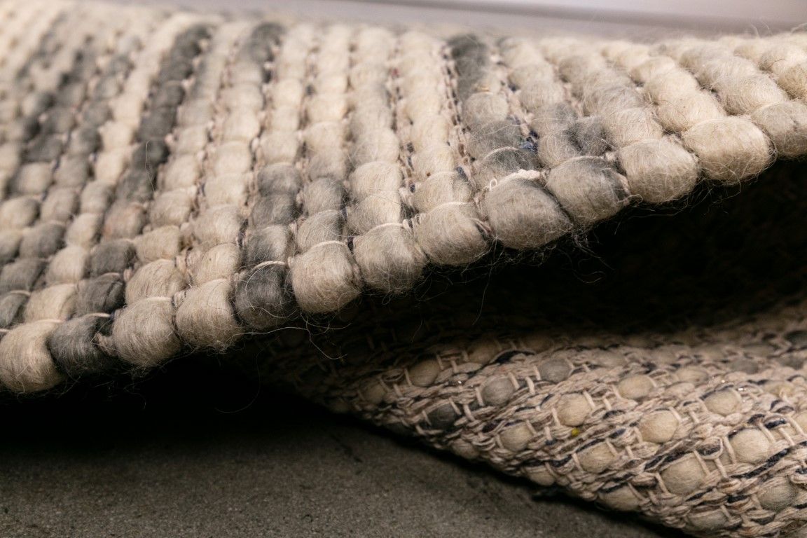 Dasha Zephyr is a texture hand woven rug made of 80%  New Zealand Wool and 20% Polyester. Colour Light Beige with Emerald Green accents. Sizes 155 X 225, 200 X 290, 240 X 320 and 300 X 400. Side.
