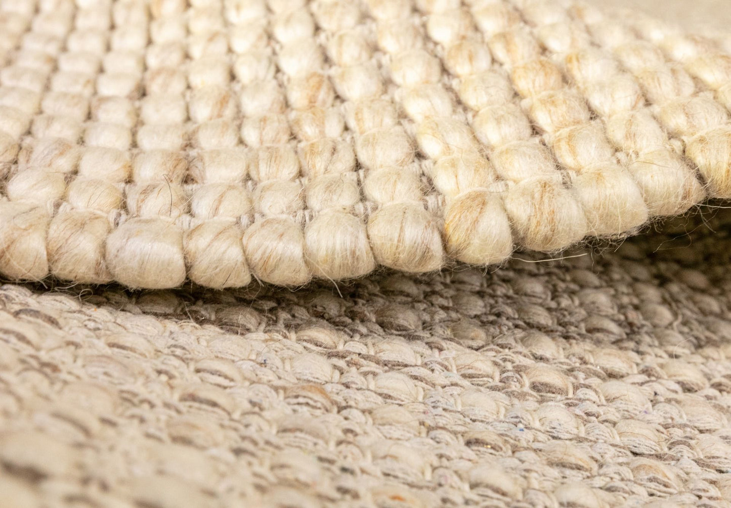 Dasha Round - Beige rug. Made of 80% wool and 20% polyester, this round rug features a unique textured design that adds a cozy and inviting feel to any room. Measuring 200cm in diameter. Side.