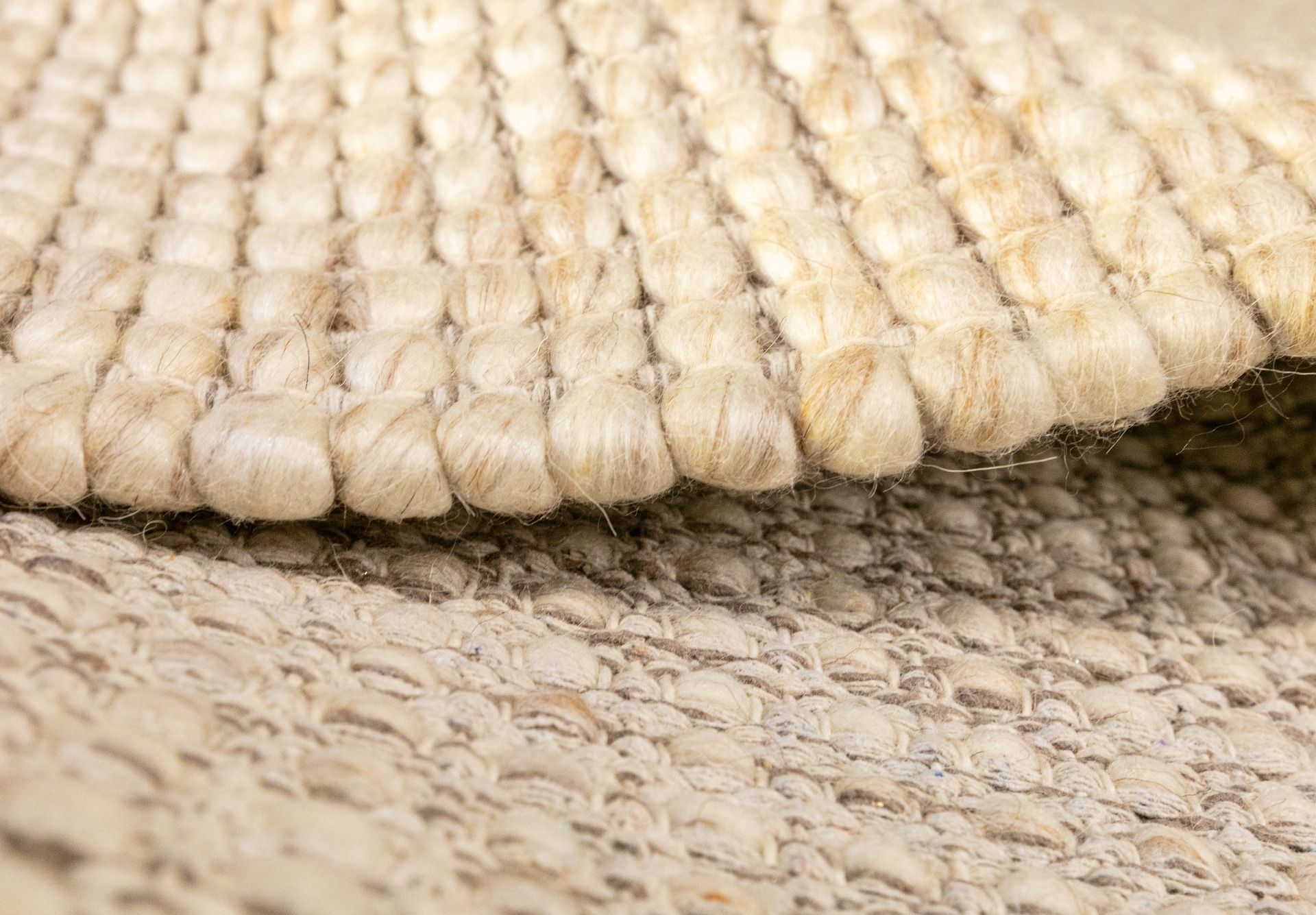 Dasha Round - Beige rug. Made of 80% wool and 20% polyester, this round rug features a unique textured design that adds a cozy and inviting feel to any room. Measuring 200cm in diameter. Side.