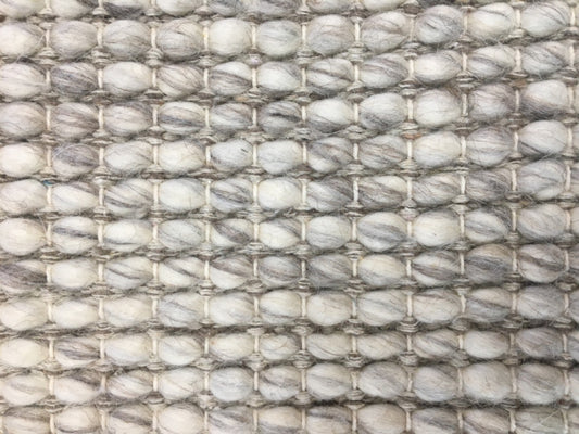 Dasha Round - Light Grey rug. Made of 80% wool and 20% polyester, this round rug features a unique textured design that adds a cozy and inviting feel to any room. Measuring 200cm in diameter. Close.