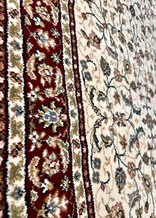 The Davinci Isfahan Beige machine-made Persian rug offers lasting style and durability, expertly crafted with heat-set polypropylene for enduring comfort. Colours, reds, beiges, greys. 4 Sizes. Side Angle.