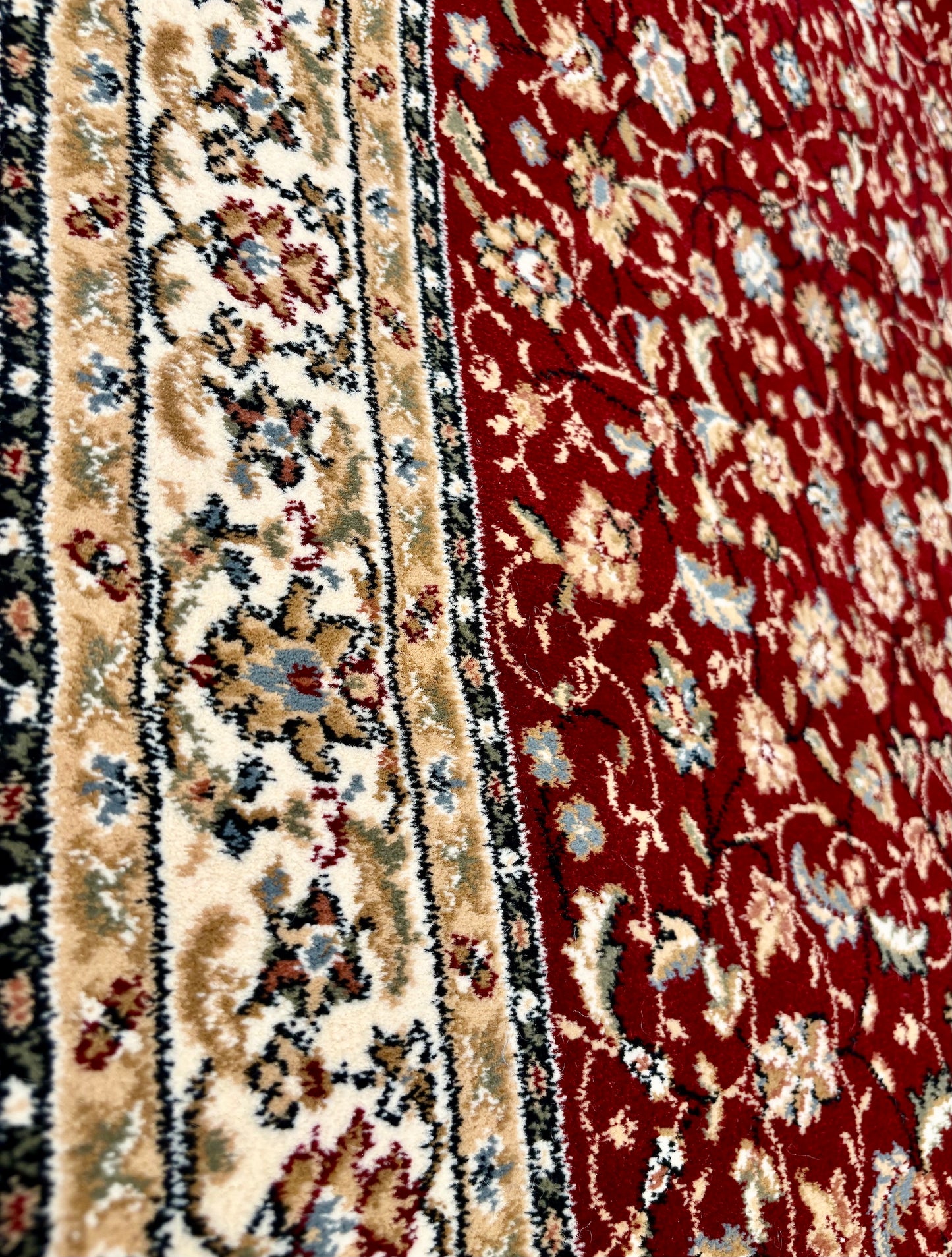 The Davinci Isfahan Red Persian Rug. Machine made and expertly crafted from durable heat-set polypropylene. Features a timeless traditional Persian design. Colours, reds, beiges, blues, greys. 4 sizes. Side Angle.
