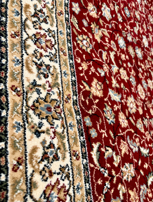 The Davinci Isfahan Red Persian Rug. Machine made and expertly crafted from durable heat-set polypropylene. Features a timeless traditional Persian design. Colours, reds, beiges, blues, greys. 4 sizes. Side Angle.