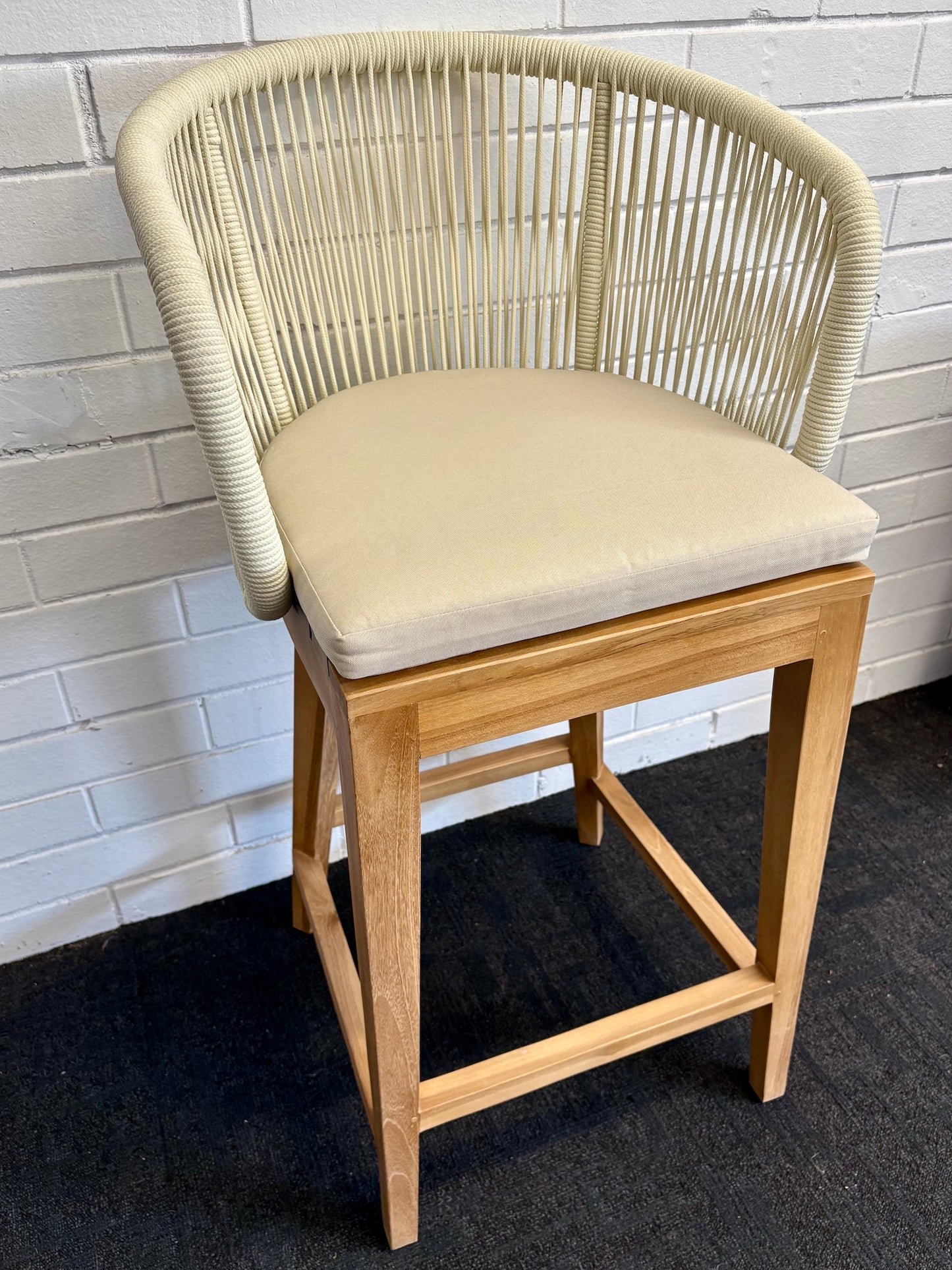 Deschutes with back barstool with solid teak wood frame,woven rope back and cotton twill seat cushion. Featuring a clean, minimalist design suitable for coastal and contemporary interiors. Measures 560 Wide X 450 Depth X 700 Seat Height X 1040 Back Height. Front Plain. Angle.