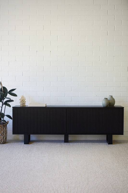 The Eastwood Black Entertainment Unit. 4 textured doors with smart storage behind the left door featuring 3 drawer. Colour Black. Measures 1800 wide X 400 depth x 650 height. Styled.