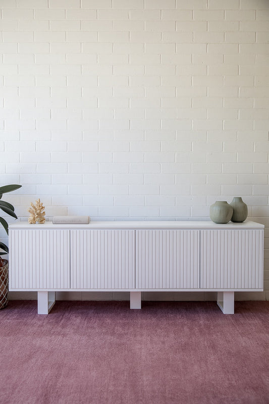 The Eastwood White Entertainment Unit. 4 textured doors with smart storage behind the left door featuring 3 drawer. Colour White. Measures 1800 wide X 400 depth x 650 height. Styled.