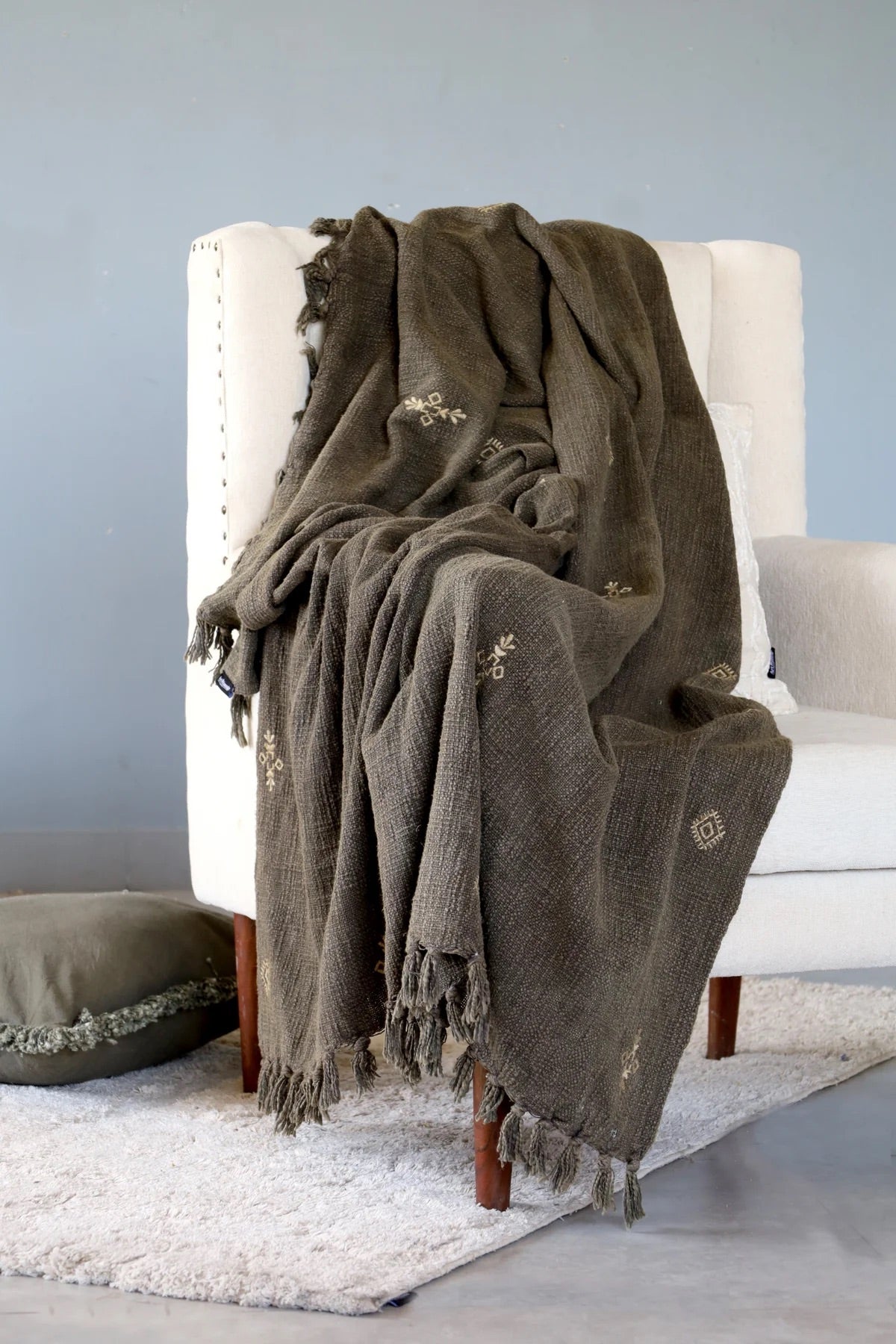Discover the beauty of Evergreen: a vibrant, hand-woven cotton slub throw, made by talented craftsmen in India. Featuring intricate tribal designs and playful tassels, this throw adds personality to any room. Colour evergreen. Size 130 X 170. Styled.
