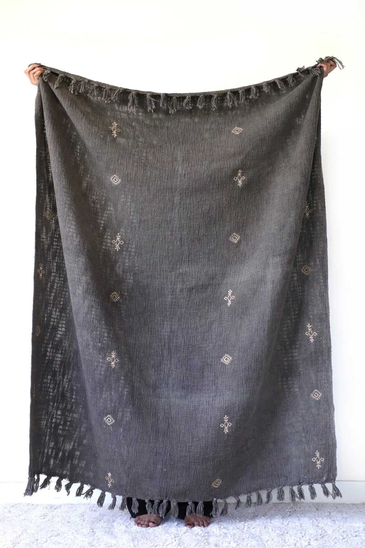 Discover the beauty of Evergreen: a vibrant, hand-woven cotton slub throw, made by talented craftsmen in India. Featuring intricate tribal designs and playful tassels, this throw adds personality to any room. Colour evergreen. Size 130 X 170. Front