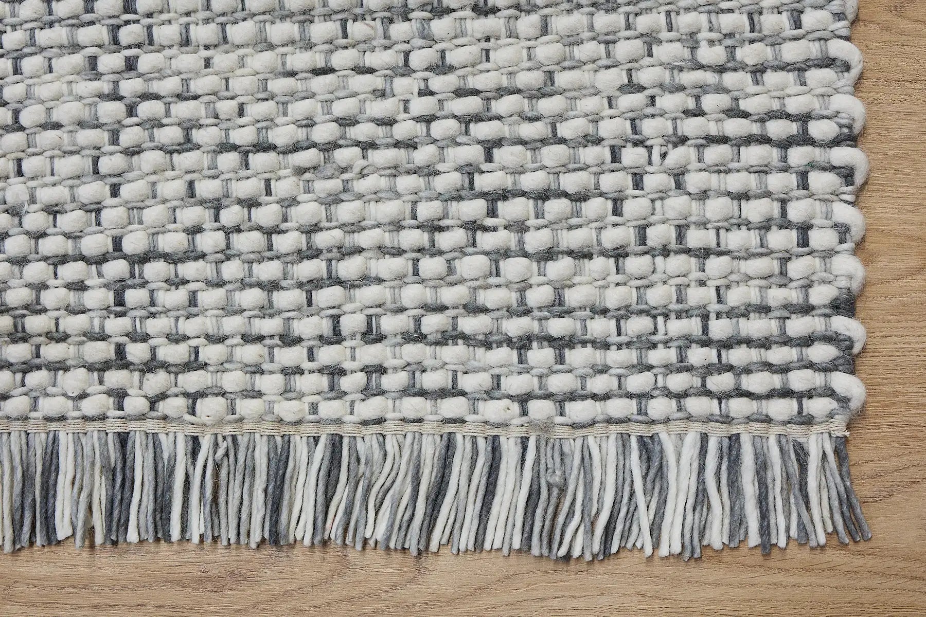 Fancy Grey is a hand braided wool rug with a sumptuous 12-14mm medium pile height. Colours White with greyish accents. Sizes 160 X 230, 200 X 290, 240 X 340 and 290 X 390. Corner.