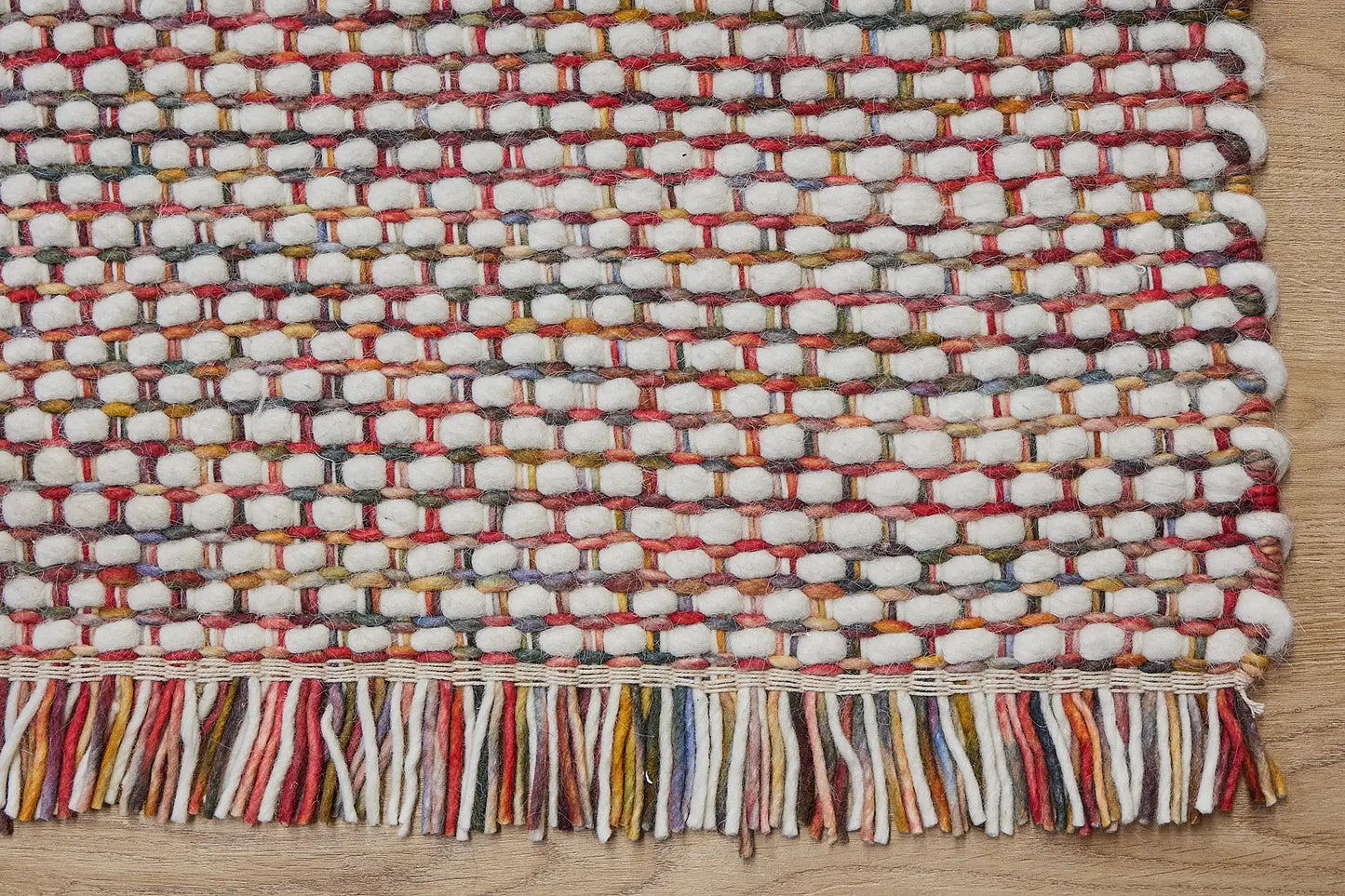 Fancy Red is a hand braided wool rug with a sumptuous 12-14mm medium pile height. Colours White with red and multi coloured accents. Corner.Fancy Red is a hand braided wool rug with a sumptuous 12-14mm medium pile height. Colours White with red and multi coloured accents. Sizes 160 X 230, 200 X 290, 240 X 340 and 290 X 390. Corner.