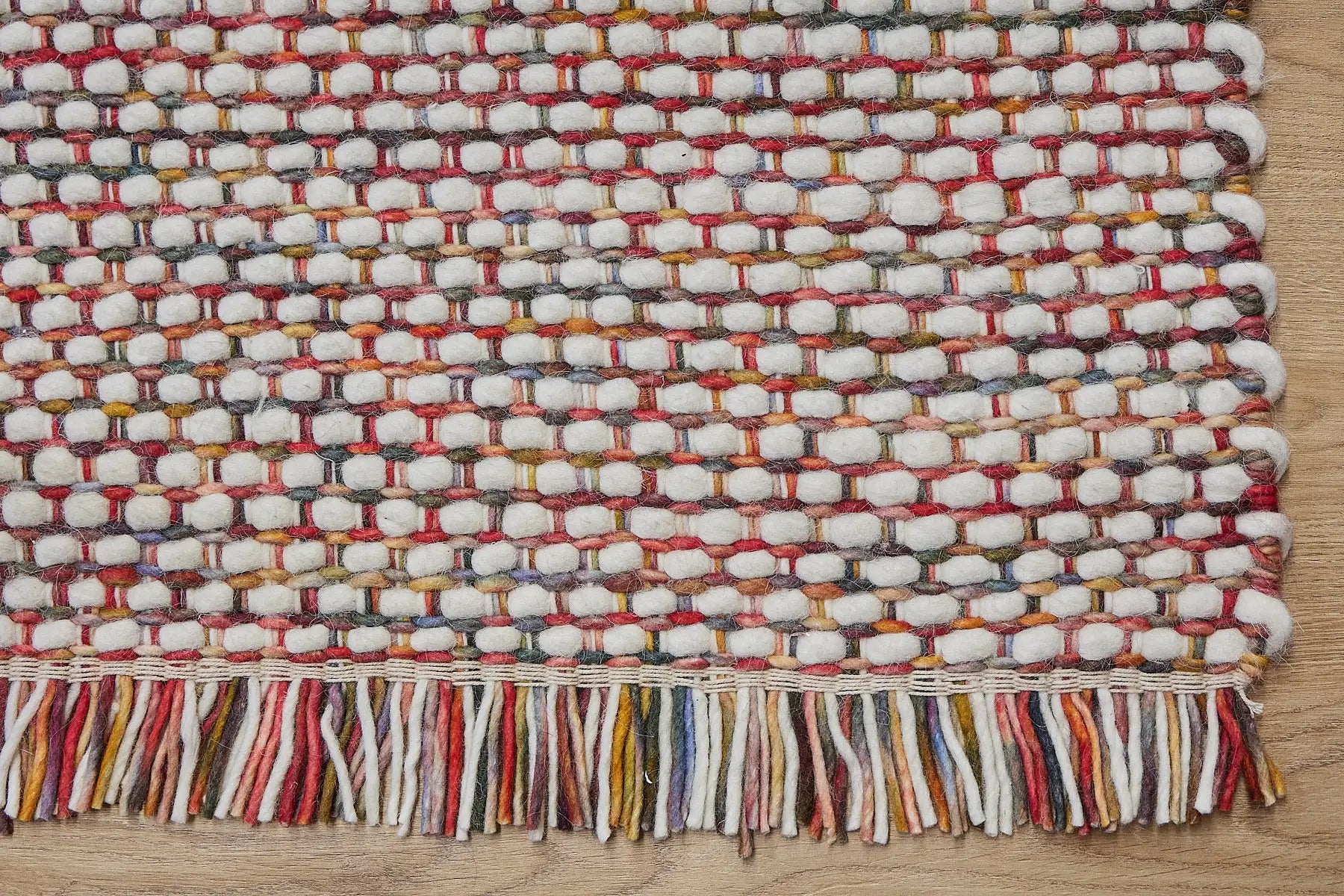 Fancy Red is a hand braided wool rug with a sumptuous 12-14mm medium pile height. Colours White with red and multi coloured accents. Corner.Fancy Red is a hand braided wool rug with a sumptuous 12-14mm medium pile height. Colours White with red and multi coloured accents. Sizes 160 X 230, 200 X 290, 240 X 340 and 290 X 390. Corner.