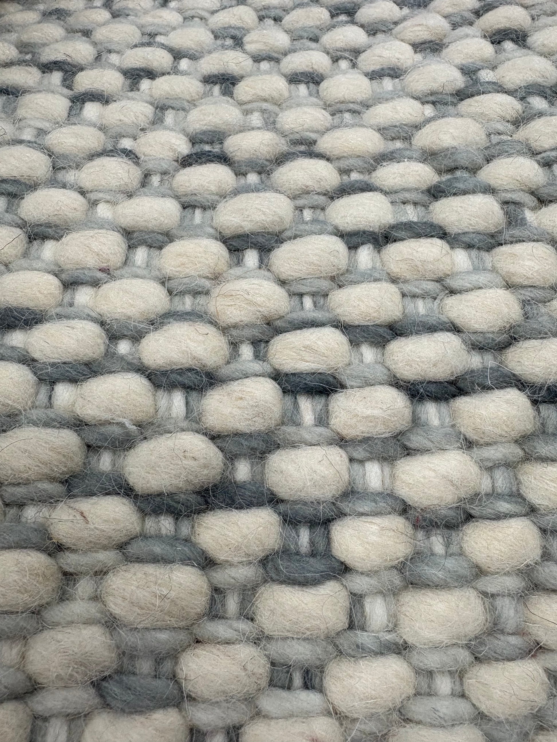 Fancy Grey is a hand braided wool rug with a sumptuous 12-14mm medium pile height. Colours White with greyish accents. Sizes 160 X 230, 200 X 290, 240 X 340. Close.