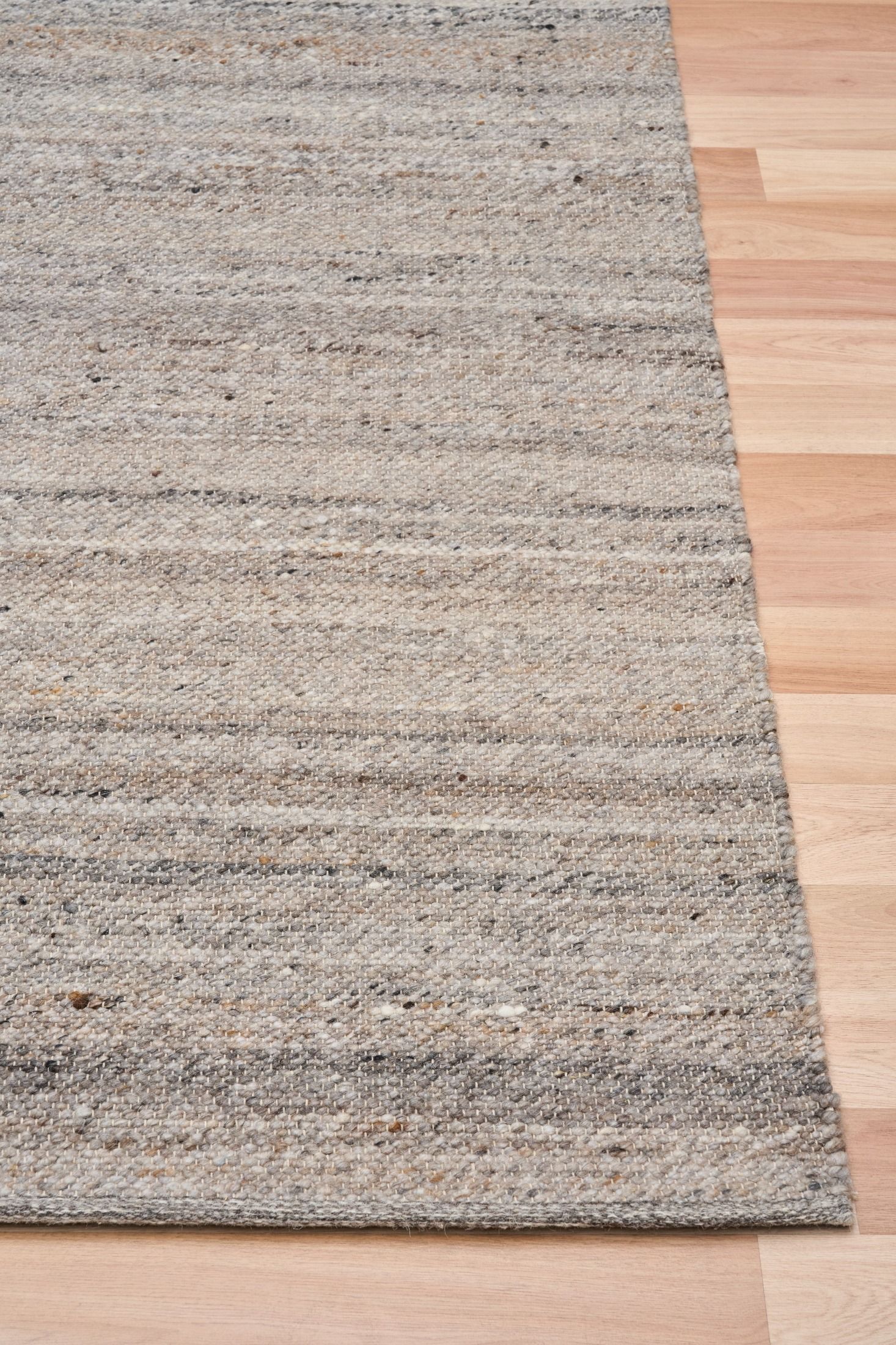 Harmony Dark Grey Rug – hand-woven blend of wool and viscose in soft natural tones, featuring a textured finish that’s both elegant and durable. Colour White, Grey, black and brown flecks. 3 sizes. Corner.