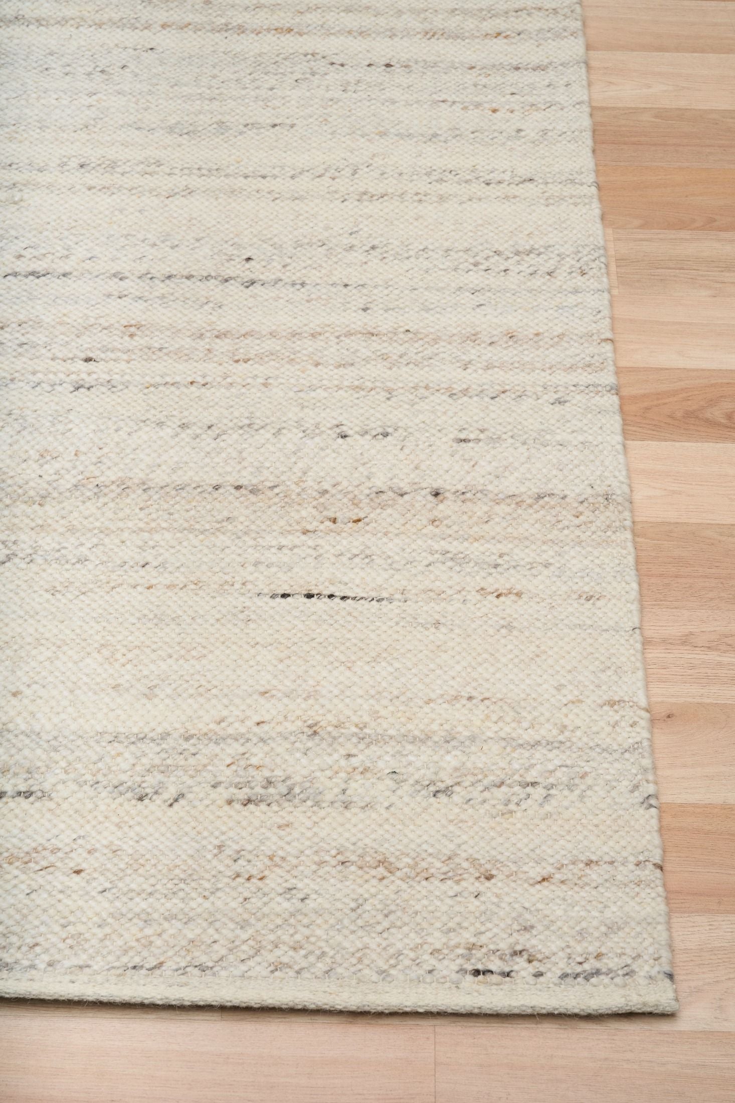 Harmony White Rug – hand-woven blend of wool and viscose in soft natural tones, featuring a textured finish that’s both elegant and durable. Colour White with black and brown fleck. 4 sizes. Corner.
