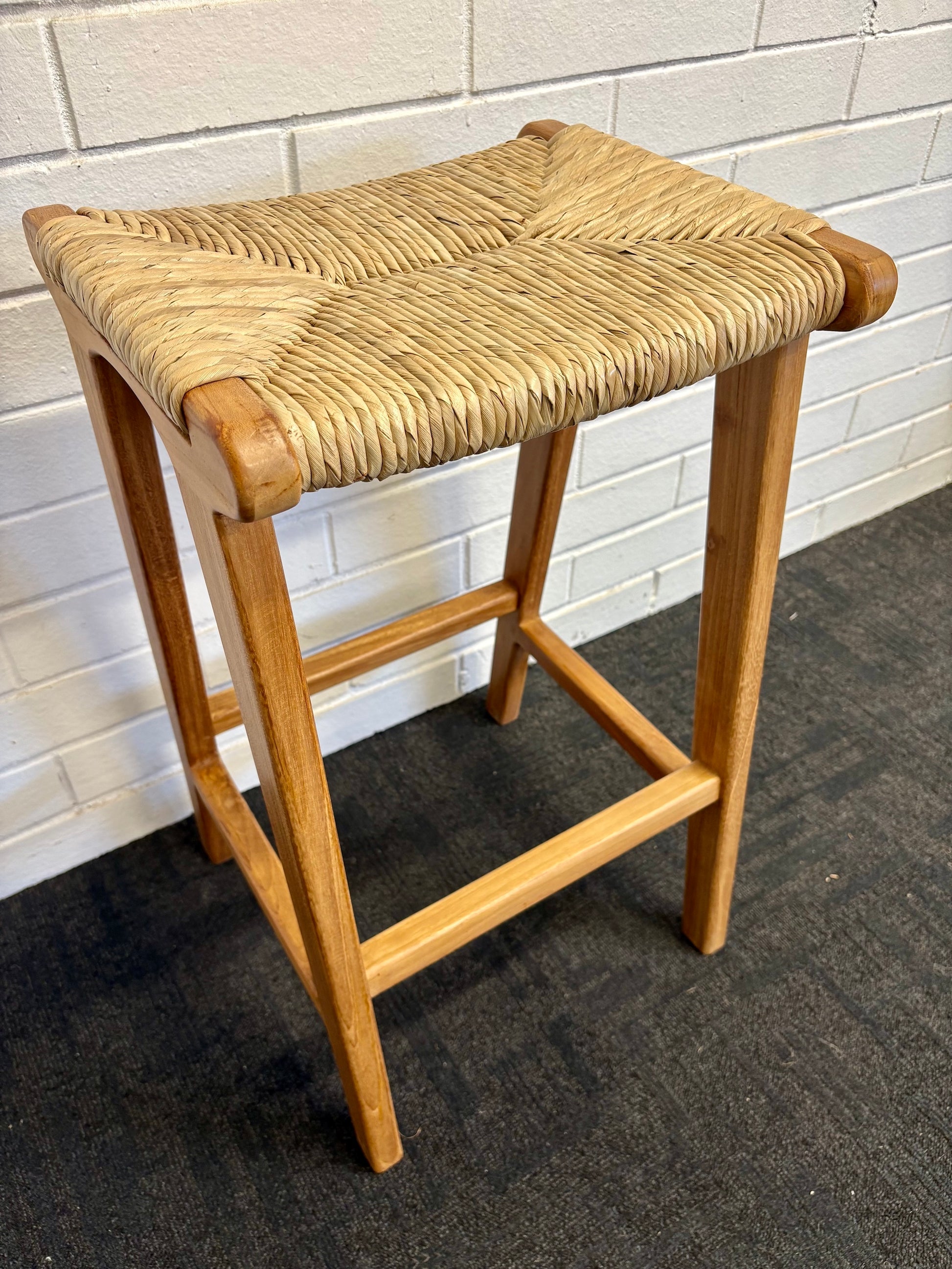 Indus barstool with solid teak wood frame and hand-woven natural pandan seat, featuring a clean, minimalist design suitable for coastal and contemporary interiors. Measures 400 Wide X 350 Depth X 680 Height. Angle.