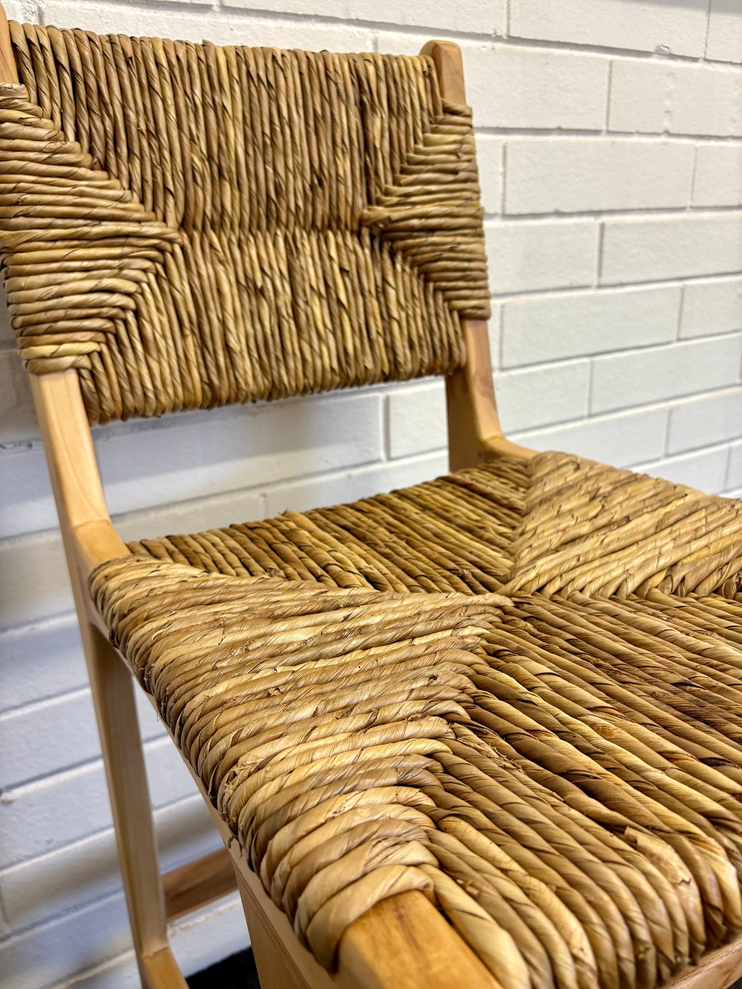 Indus with back barstool with solid teak wood frame and hand-woven natural pandan seat and back, featuring a clean, minimalist design suitable for coastal and contemporary interiors. Measures 410 Wide X 540 Depth X 670 Seat Height X 1000 Back Height.  Close.