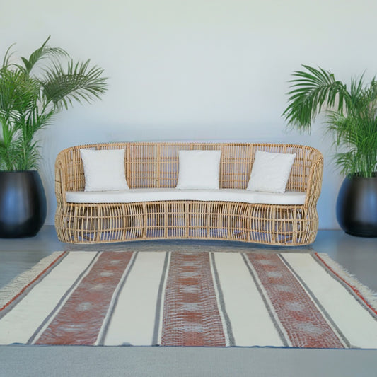 The Kalahari Lounge is an indoor/outdoor lounge. Featuring a rattan frame and UV resistant cushioned seat and back. Colours, natural and white cushions. Measures 2400 length x 900 depth x 900 height with 460 seat height. Styled.