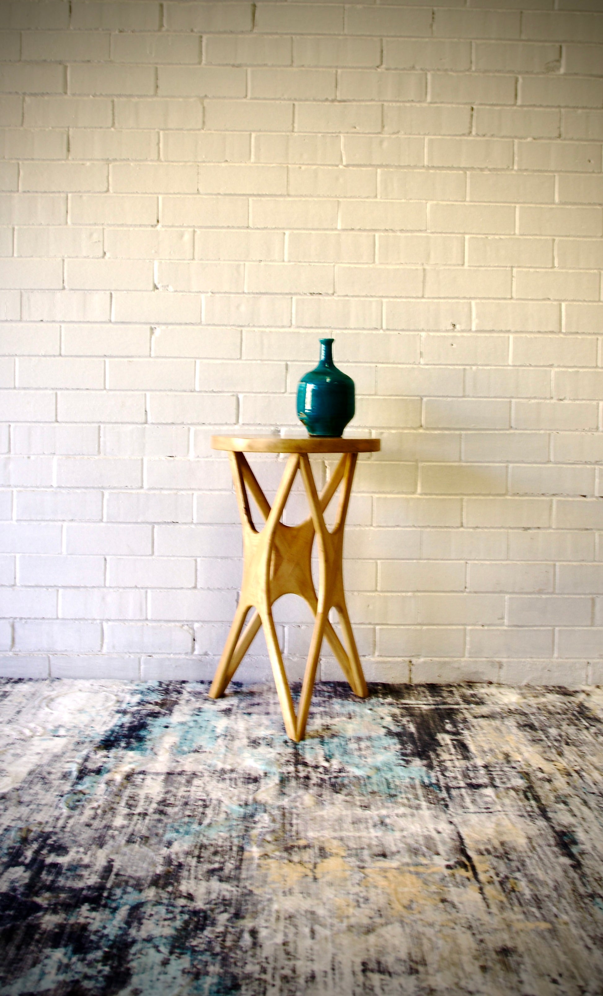 The Kamakura Side Table is crafted from sustainable fruitwood. Features a round top with cross-legged styled legs.  Colour natural. Measures  400 diameter X 660 height. Front Styled.