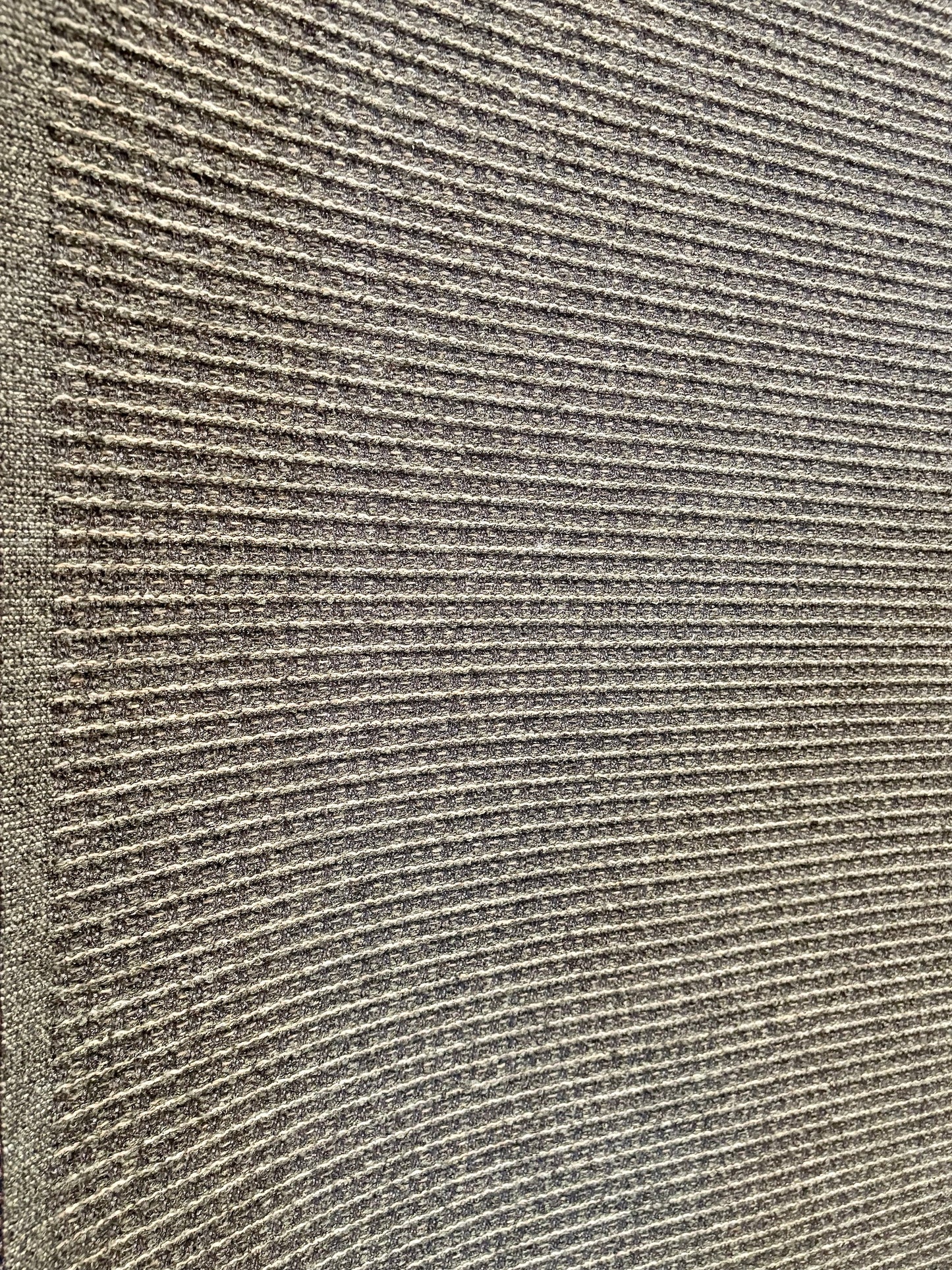 Katana Forest indoor/outdoor rug featuring deep green and light grey tones and a subtle textured pattern, power-loomed from UV-stabilised polypropylene for lasting durability. Colour forest green and light greys. 3 sizes. Angle.