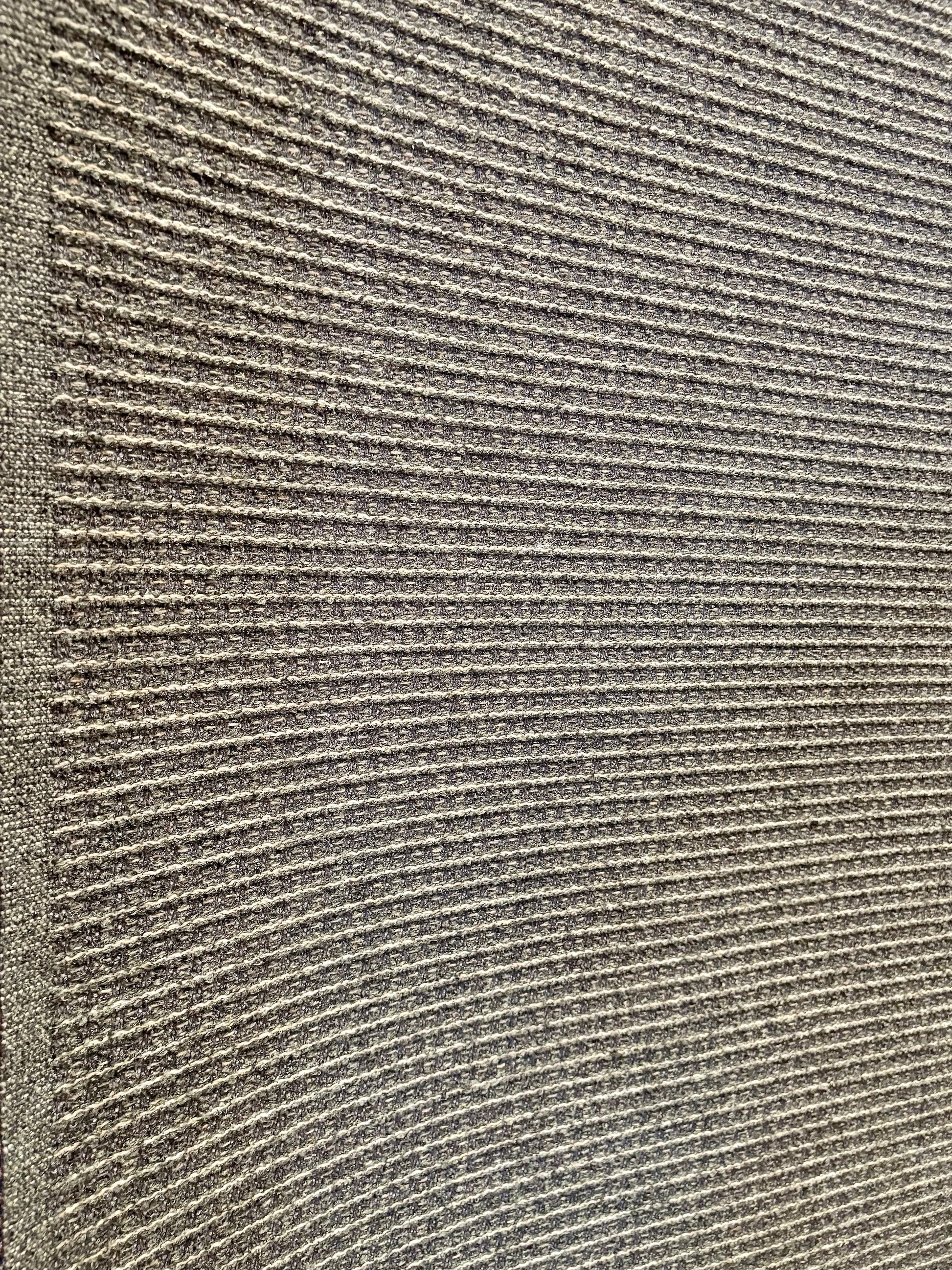 Katana Forest indoor/outdoor rug featuring deep green and light grey tones and a subtle textured pattern, power-loomed from UV-stabilised polypropylene for lasting durability. Colour forest green and light greys. 3 sizes. Angle.