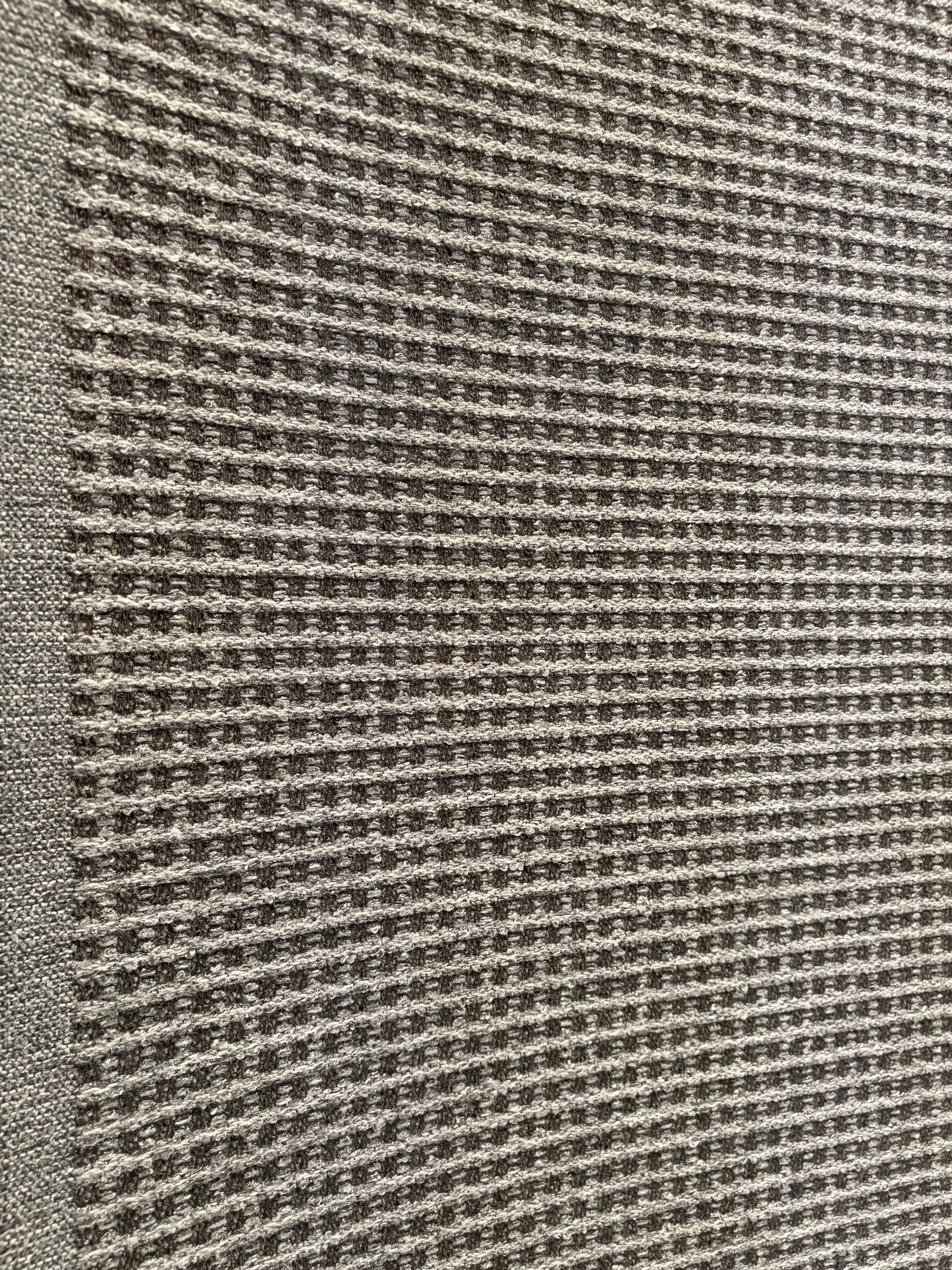 Katana Grey indoor/outdoor rug featuring a subtle textured pattern, power-loomed from UV-stabilised polypropylene for lasting durability. Colour grey. 3 sizes. Angle.