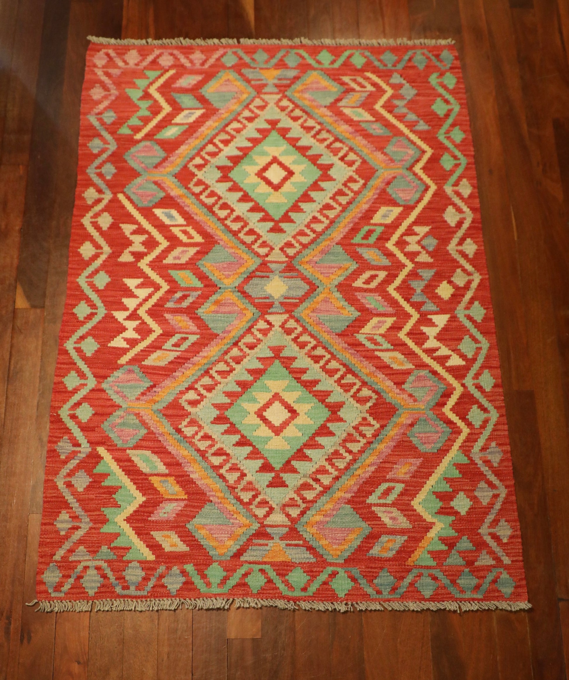 The Afghan Hand Woven Khyber Kilim - 124 X 176. Crafted using traditional vegetable dyed wool, and featuring traditional geometric designs. Colours, Oranges, beiges, creams, lavender. Size 124 X 176. Top.
