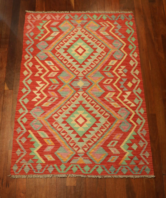 The Afghan Hand Woven Khyber Kilim - 124 X 176. Crafted using traditional vegetable dyed wool, and featuring traditional geometric designs. Colours, Oranges, beiges, creams, lavender. Size 124 X 176. Top.