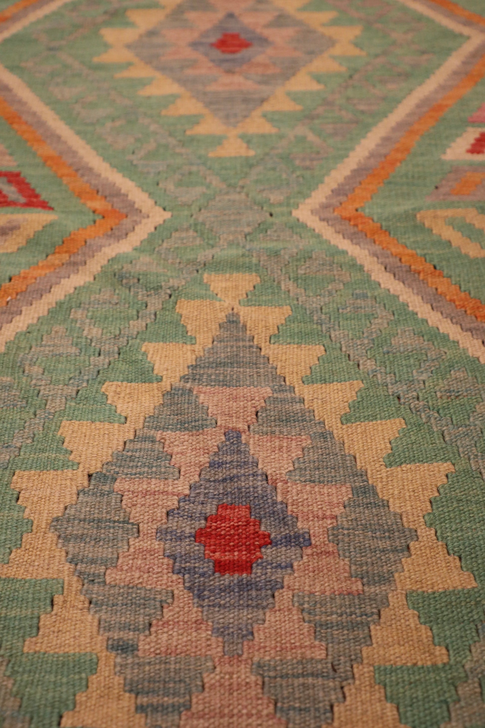 The Afghan Hand Woven Khyber Kilim - 126 X 179. Crafted using traditional vegetable dyed wool, and featuring traditional geometric designs. Colours, greens, beiges, creams, oranges. Size 126 X 179. Close.