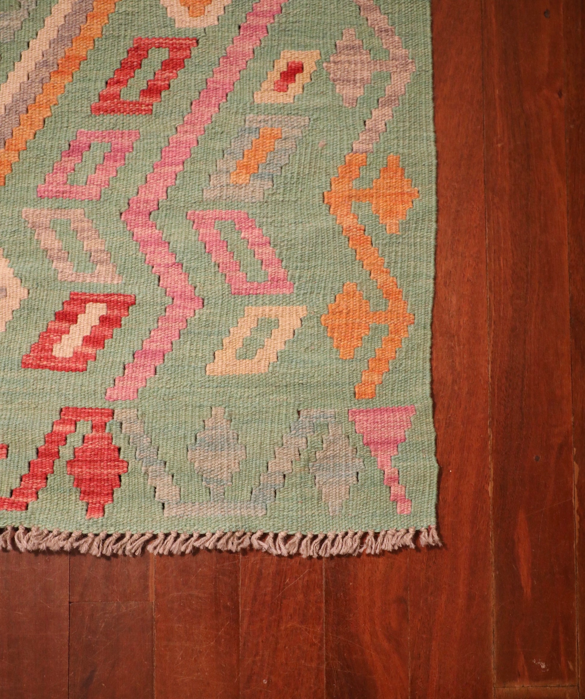 The Afghan Hand Woven Khyber Kilim - 126 X 179. Crafted using traditional vegetable dyed wool, and featuring traditional geometric designs. Colours, greens, beiges, creams, oranges. Size 126 X 179. Corner.